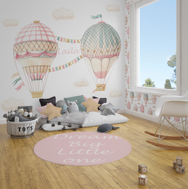 The image features elegant, pastel-colored hot air balloons with intricate patterns and decorative bunting connecting them, accompanied by fluffy clouds in a soft watercolor style. The name "Laila" is written between the balloons in a gentle script, adding a personalized touch. The composition evokes a dreamy and serene atmosphere, perfect for a whimsical or child-themed design.