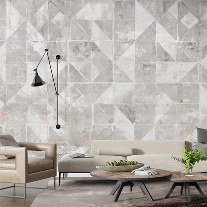 A geometric mural featuring weathered concrete tiles with various triangular and square patterns in soft gray and white tones. The distressed texture adds an industrial, minimalist, and modern aesthetic to the design.